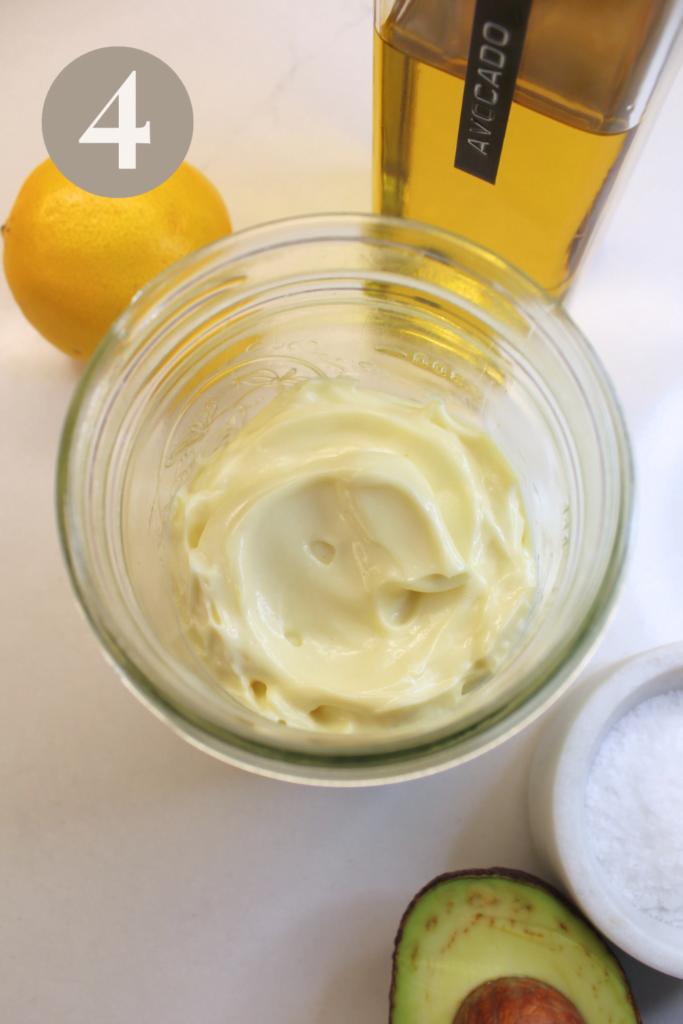 Finished avocado oil mayo surrounded by avocado salt, oil and lemon.