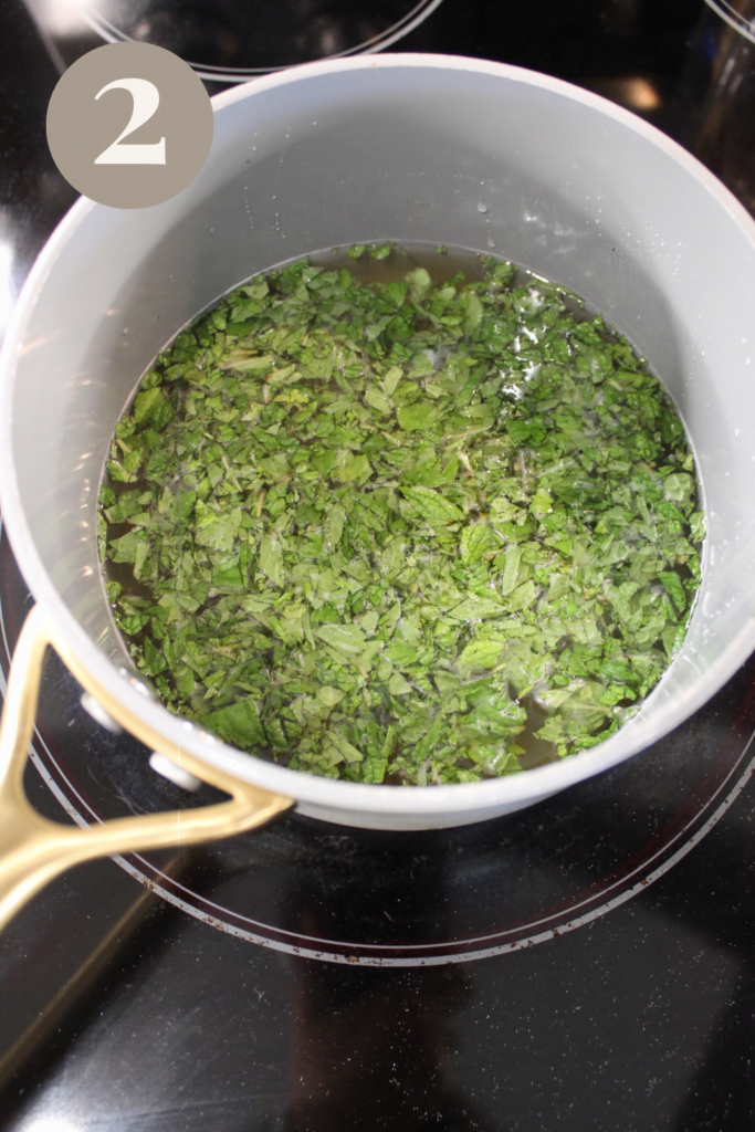 Boiling mint simple syrup in a ceramic pot.