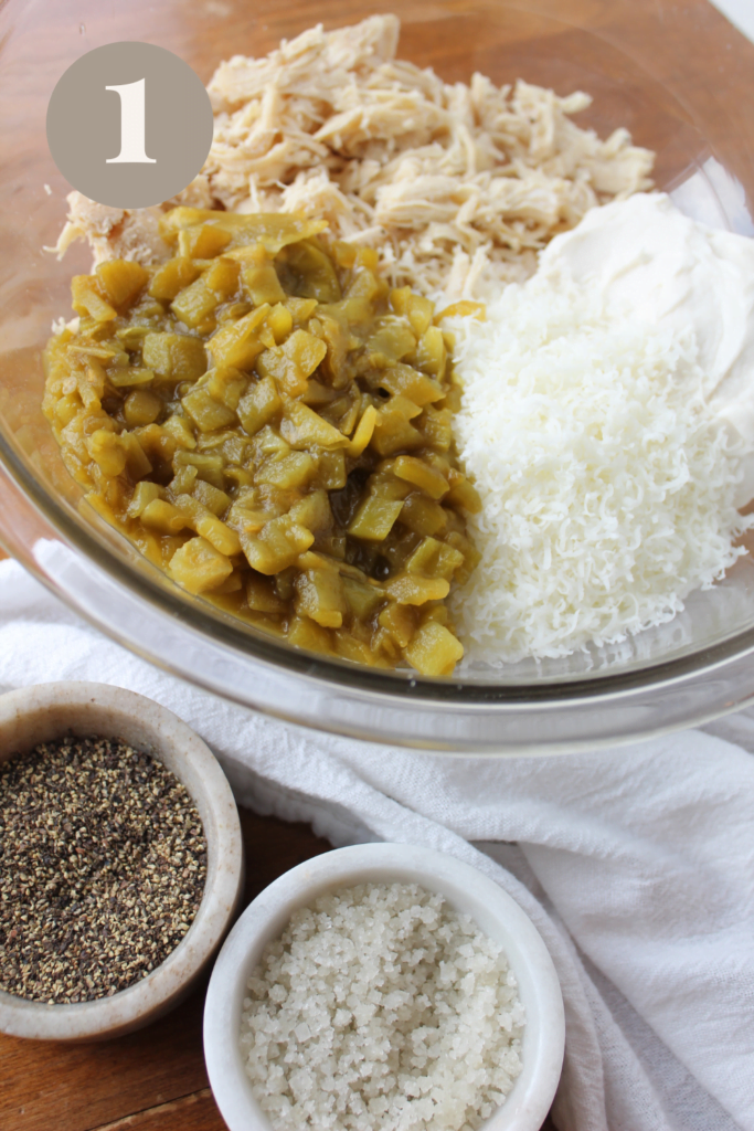 All enchilada ingredients all placed in a glass mixing bowl.