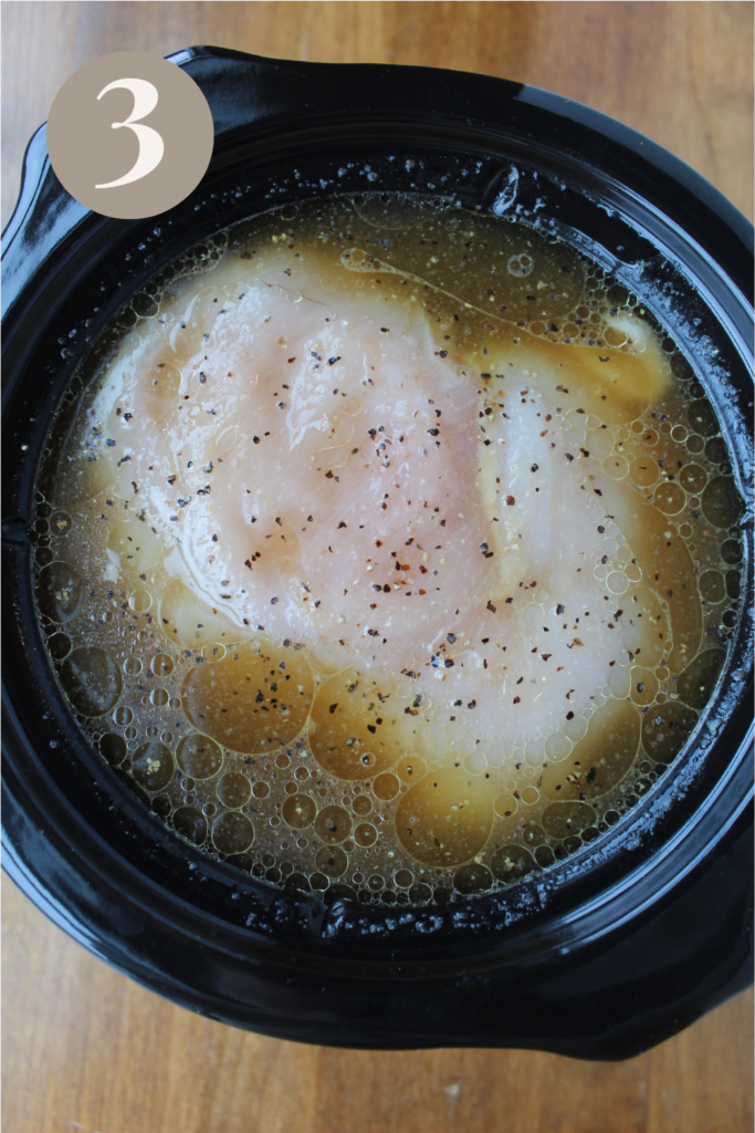 Mixed ingredients into the crockpot on a wood table.
