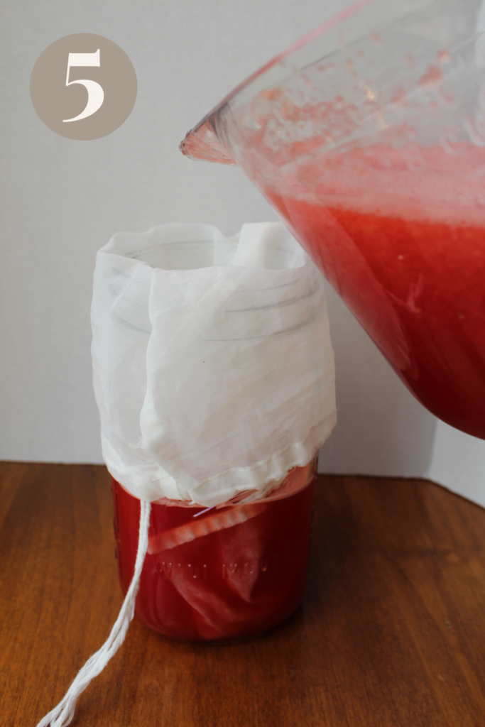 Straining watermelon juice with a cheese cloth.