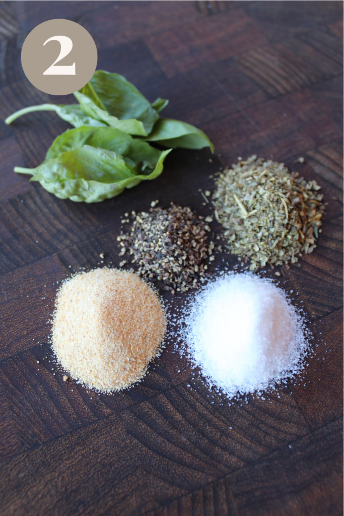 Seasonings and basil on a cutting board.