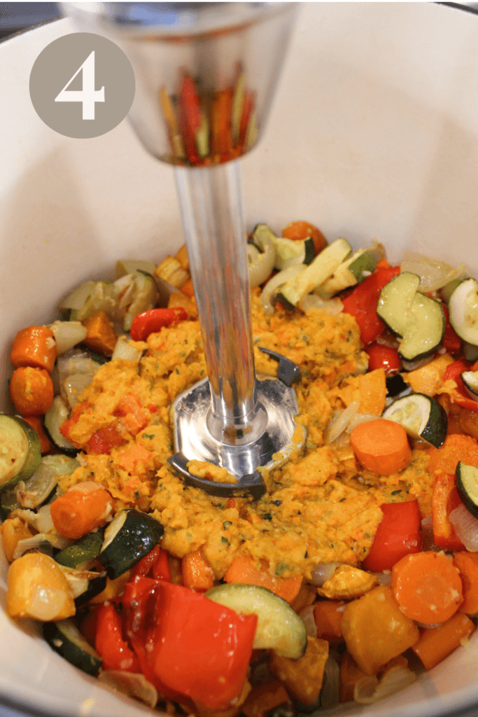 Blending roasted veggies in a big pot.