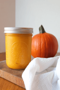Pumpkin Puree in a jar next to a pumpkin.