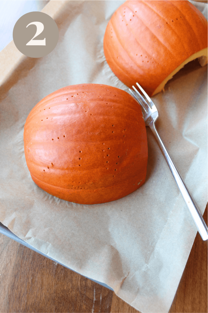 Two halves of a pumpkin pierced with a fork.