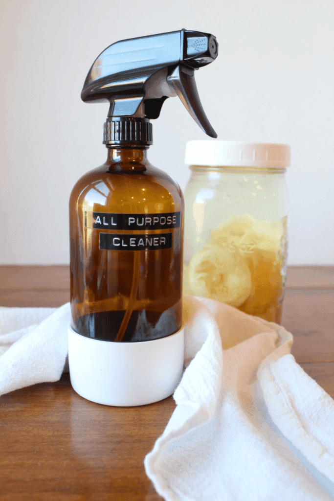 All-purpose cleaner, towel and lemon vinegar on a table.