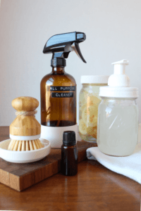 Homemade spray, soap and vinager with a scrubby sitting on a table.