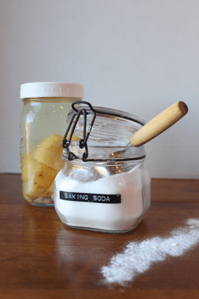 Drain cleaner, baking soda and lemon vinegar on a table.