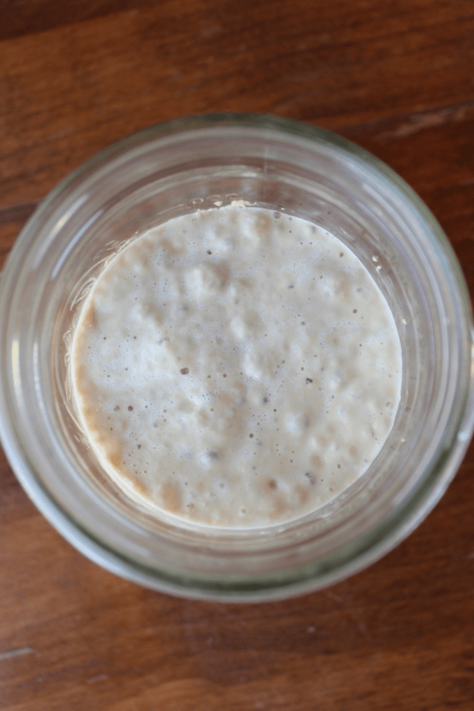 Blooming activated yeast in a mason jar on the counter.