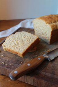 Slices of bread on a cutting board with a knife.
