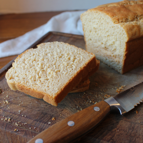 Slices of bread on a cutting board with a knife.