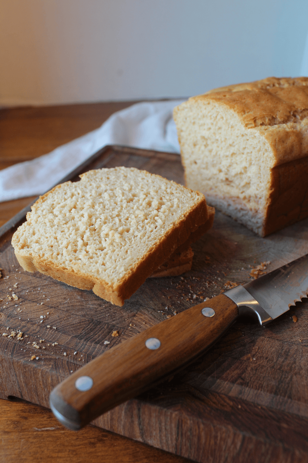 Slices of bread on a cutting board with a knife.