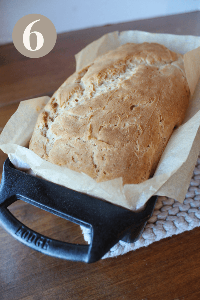 Bread loaf in a cast iron pan with a golden top.
