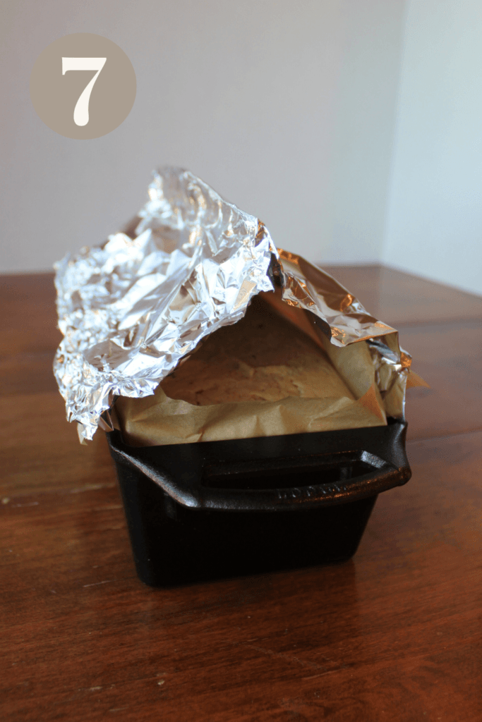 Bread loaf out of oven with a piece of tin foil tented over the top.