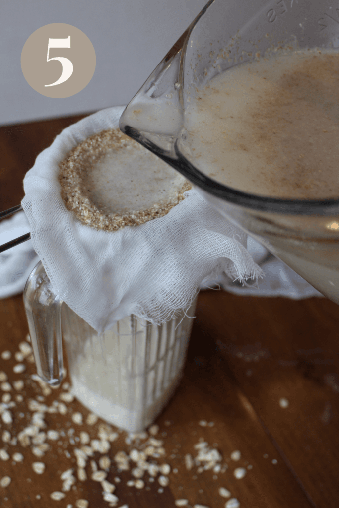 Oat milk being poured into a glass pitcher with a cheese cloth.