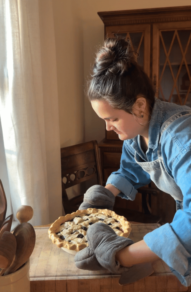 Mikayla taking a pie out of the oven.